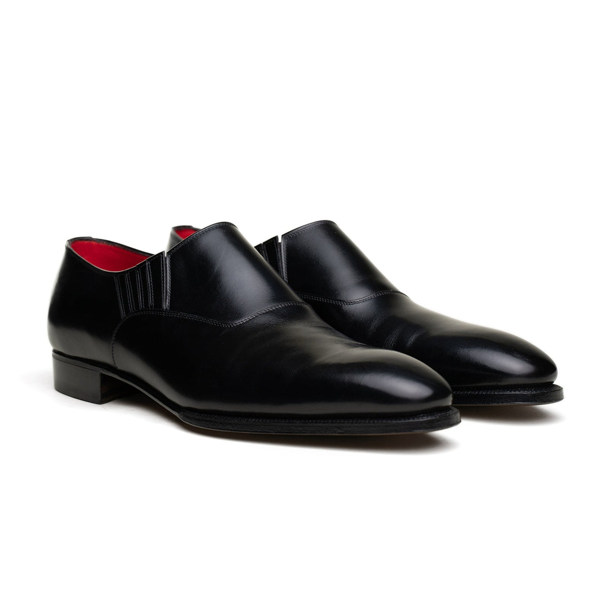 A pair of black leather dress shoes with a handwelted construction and leather lining, displaying a sleek design with subtle stitching details.